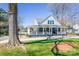 Charming home featuring a covered porch, mature trees, and a well-manicured front yard at 704 N Main Ave, Newton, NC 28658