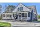Beautiful blue house with a classic white porch, complemented by lush greenery and a welcoming entrance at 704 N Main Ave, Newton, NC 28658