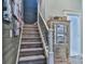 Wooden staircase with carpet runner, decorative cabinet, and Gathering photos at 704 N Main Ave, Newton, NC 28658
