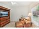 Inviting bedroom with comfortable armchair, TV, and natural light filtering through a window with outdoor views at 727 Mayfield Ct, Fort Mill, SC 29715