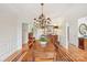 This dining room features hardwood floors, with an elegant chandelier and views into the kitchen at 727 Mayfield Ct, Fort Mill, SC 29715