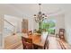 Elegant dining room featuring a wooden table, chandelier, large window, and hardwood floors at 727 Mayfield Ct, Fort Mill, SC 29715
