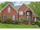 Beautiful red brick home with a manicured lawn, mature landscaping and a charming, symmetrical facade at 727 Mayfield Ct, Fort Mill, SC 29715