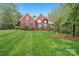 Beautiful red brick home with a manicured lawn, mature landscaping and a charming, symmetrical facade at 727 Mayfield Ct, Fort Mill, SC 29715