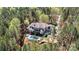 An aerial view of a beautiful home with a backyard pool nestled amongst dense trees providing excellent privacy at 7509 Webbs Chapel Cove Ct, Denver, NC 28037