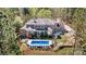 Stunning brick home boasts a refreshing backyard pool and an expansive outdoor patio area surrounded by lush trees at 7509 Webbs Chapel Cove Ct, Denver, NC 28037