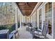 Relax on this covered porch complete with ceiling fans, rocking chairs, and brick flooring at 7509 Webbs Chapel Cove Ct, Denver, NC 28037