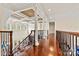 Open hallway with hardwood floors, tall columns, and staircase leading to the main level at 7509 Webbs Chapel Cove Ct, Denver, NC 28037