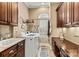 Well-appointed laundry room with wood cabinets, granite counters, laundry sink, and natural light at 7509 Webbs Chapel Cove Ct, Denver, NC 28037