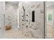 Elegant shower with marble-style tile, pebble floor, multi-spray fixtures, and built-in shelving at 7509 Webbs Chapel Cove Ct, Denver, NC 28037