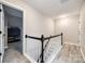 Hallway with black and white staircase leading to a well-lit upper level with modern flooring at 810 Rock Lake Gln, Fort Mill, SC 29715
