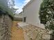 Home's exterior backyard featuring a patio and stone walkway, with lush greenery on either side at 9037 Pembroke Ct, Fort Mill, SC 29707