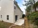 Exterior backyard featuring a patio and stone walkway, with lush greenery surrounding the home at 9037 Pembroke Ct, Fort Mill, SC 29707