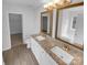 Bathroom featuring a double sink vanity with granite countertops and framed mirrors at 9037 Pembroke Ct, Fort Mill, SC 29707