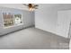 Spacious bedroom featuring a large window, ceiling fan and light colored walls and neutral carpeting at 9037 Pembroke Ct, Fort Mill, SC 29707