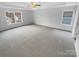 Expansive primary bedroom featuring a tray ceiling, carpet and two large windows bringing in natural light at 9037 Pembroke Ct, Fort Mill, SC 29707