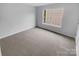 Bright bedroom featuring a large window, neutral walls and neutral carpeting at 9037 Pembroke Ct, Fort Mill, SC 29707