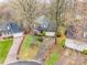An aerial view of a landscaped suburban home with a two-car garage, surrounded by mature trees at 9238 Heritage Woods Pl, Charlotte, NC 28269