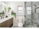 Modern bathroom featuring gray tile, vanity with plants, and a glass shower stall at 9238 Heritage Woods Pl, Charlotte, NC 28269