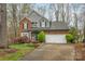 Charming two-story brick home featuring an attached two-car garage and well-manicured landscaping at 9238 Heritage Woods Pl, Charlotte, NC 28269