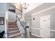 Bright, open foyer featuring a staircase, hardwood floors, and views into adjacent living spaces at 9238 Heritage Woods Pl, Charlotte, NC 28269