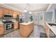 Bright kitchen with a center island, stainless steel appliances, and light wood cabinets at 9238 Heritage Woods Pl, Charlotte, NC 28269