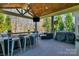 This covered patio includes an outdoor bar area, comfortable seating, and a mounted television at 1005 Palace Ct # 58, Indian Trail, NC 28079
