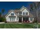 Two-story home with a well-manicured lawn, inviting porch with red chairs, and classic curb appeal at 1005 Palace Ct # 58, Indian Trail, NC 28079