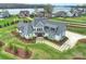 Aerial view of a luxurious modern farmhouse nestled by the lake with meticulous landscaping at 101 S Shore Dr, Belmont, NC 28012