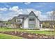 A modern farmhouse showcasing its elegant exterior design, complemented by lush landscaping at 101 S Shore Dr, Belmont, NC 28012