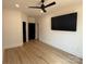 A cozy bedroom featuring wood floors, a ceiling fan, and a mounted television at 108 Winners Cir # 5, Mooresville, NC 28117