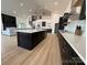Modern kitchen with dark cabinets, a large island, stainless steel appliances, and a view of the living area at 108 Winners Cir # 5, Mooresville, NC 28117