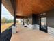 Beautiful porch featuring wood ceiling, stone accents, and dark modern trim and black door frames at 108 Winners Cir # 5, Mooresville, NC 28117