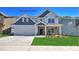 Charming two-story home with a manicured lawn, a two-car garage, and lovely stone detailing at 116 Asmodean Ln, Troutman, NC 28166