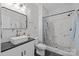 Stylish bathroom featuring white marble tile, walk-in shower, dark fixtures, and vanity with vessel sink at 1205 Brooksland Pl, Waxhaw, NC 28173