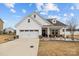 Charming, single story home features a manicured lawn, two-car garage, and covered porch with rocking chairs at 1205 Brooksland Pl, Waxhaw, NC 28173