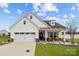Charming single-Gathering home featuring white siding, a two-car garage, and a welcoming front porch at 1205 Brooksland Pl, Waxhaw, NC 28173