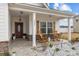 Charming front porch with rocking chairs, decorative shutters, and stone accents at 1205 Brooksland Pl, Waxhaw, NC 28173
