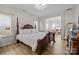 Bright main bedroom showcasing a four-poster bed, wood floors and open access to the living room at 1205 Brooksland Pl, Waxhaw, NC 28173