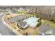 Aerial view of a community pool, pool house, parking, manicured landscaping, and surrounding neighborhood homes at 1205 Brooksland Pl, Waxhaw, NC 28173