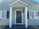 Inviting home entrance featuring a stylish front door, decorative lantern, and windows with dark shutters at 1239 Mitchell Ave, Statesville, NC 28677