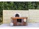 Exterior view of a pizza oven surrounded by a wooden fence and greenery at 126 Goat Trl, China Grove, NC 28023