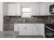 Stylish kitchen with white cabinets, stainless steel appliances, and a mosaic tile backsplash at 1305 Price Ave, Kannapolis, NC 28081