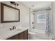 This bathroom features a white marble tiled shower, brown vanity, white sink, mosaic floors and window at 132 Shady Grove Rd, Kings Mountain, NC 28086