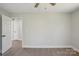 This bedroom features gray walls, wood-look floors, base molding and an open doorway to another part of the house at 132 Shady Grove Rd, Kings Mountain, NC 28086