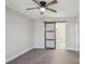 This bedroom features gray walls, wood-look floors, base molding and a sliding barn door to a bathroom at 132 Shady Grove Rd, Kings Mountain, NC 28086