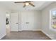 This bedroom features gray walls, wood-look floors, a ceiling fan, a window, and a closet for ample storage at 132 Shady Grove Rd, Kings Mountain, NC 28086