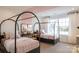Charming bedroom featuring twin beds with modern frames, soft pink bedding, and bright, sunny window at 13943 Penbury Ln # 376, Charlotte, NC 28278