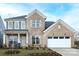 Charming two-story brick home with a manicured lawn and inviting front porch with rocking chairs at 13943 Penbury Ln # 376, Charlotte, NC 28278