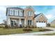 Charming two-story brick home with a manicured lawn and inviting front porch with rocking chairs at 13943 Penbury Ln # 376, Charlotte, NC 28278